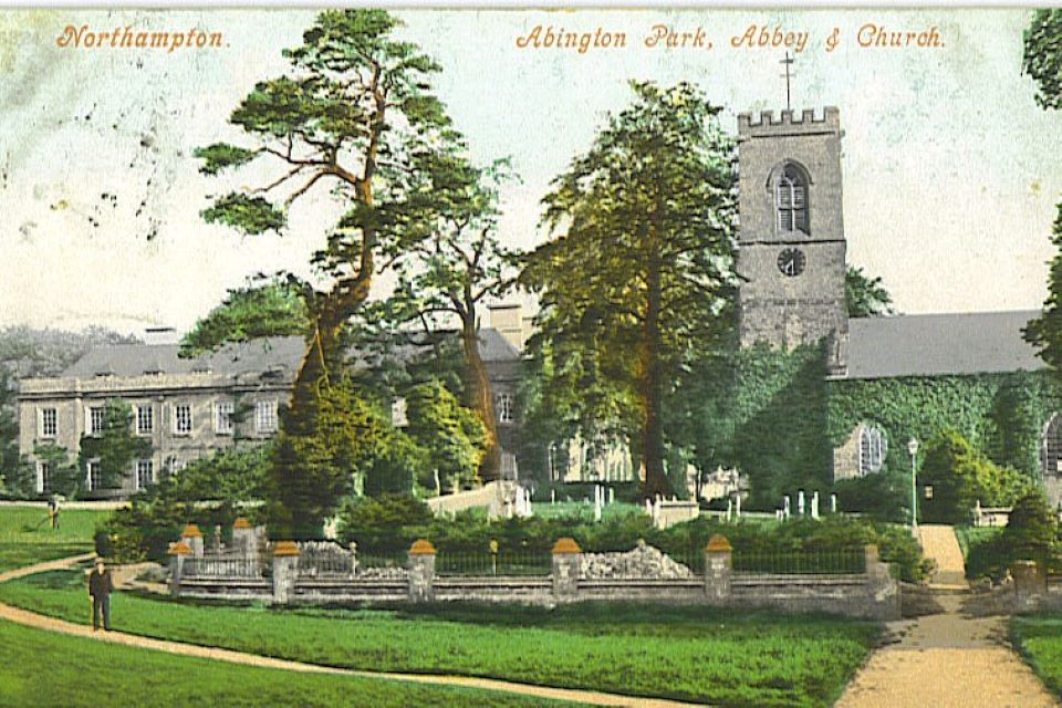 Postcard image of Abington Park Museum with tress and parkland in front of the building..