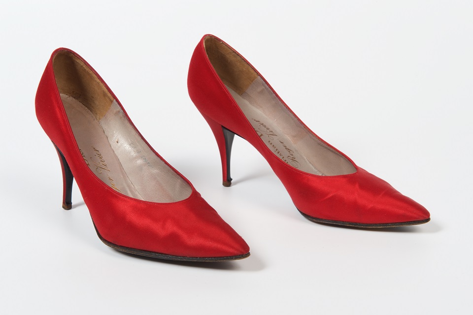 Photograph showing a pair of women's red silk court shoes with stiletto heels.