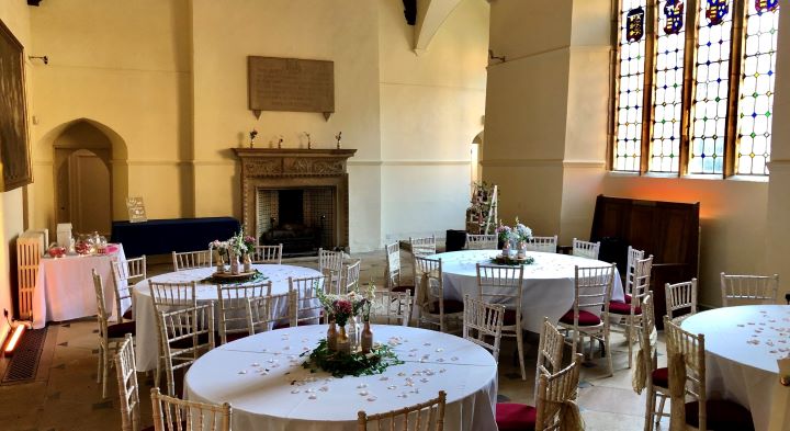 Image of the Great Hall with round tables and chairs set out for a wedding reception.