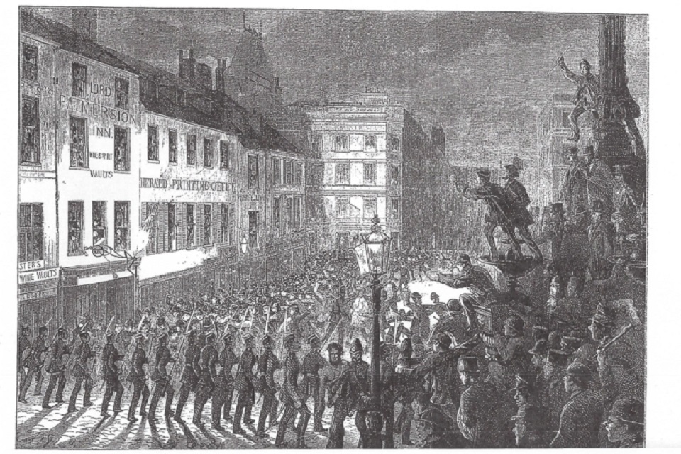 Group of people in the foreground all shouting and throwing objects, with buildings in the background.