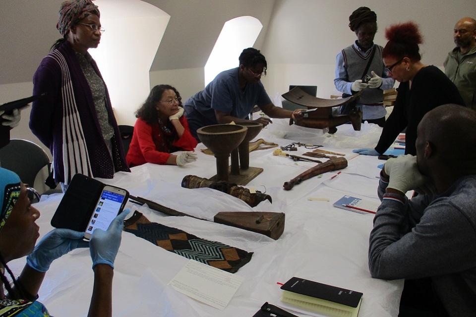 Group of people gathered around a table looking at objects