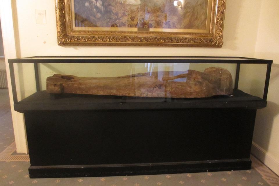 Black display case with horizontal Egyptian coffin lid.