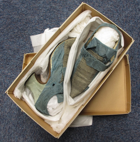 A card box packed with tissue holding two shoes.