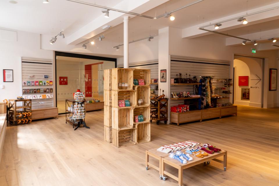 Image looking into shop with stands on floor and goods for sale on the walls.