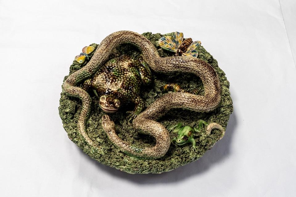 Circular object ddepicting a snake in the grass.