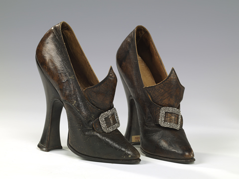 A pair of high healed and buckled shoes.