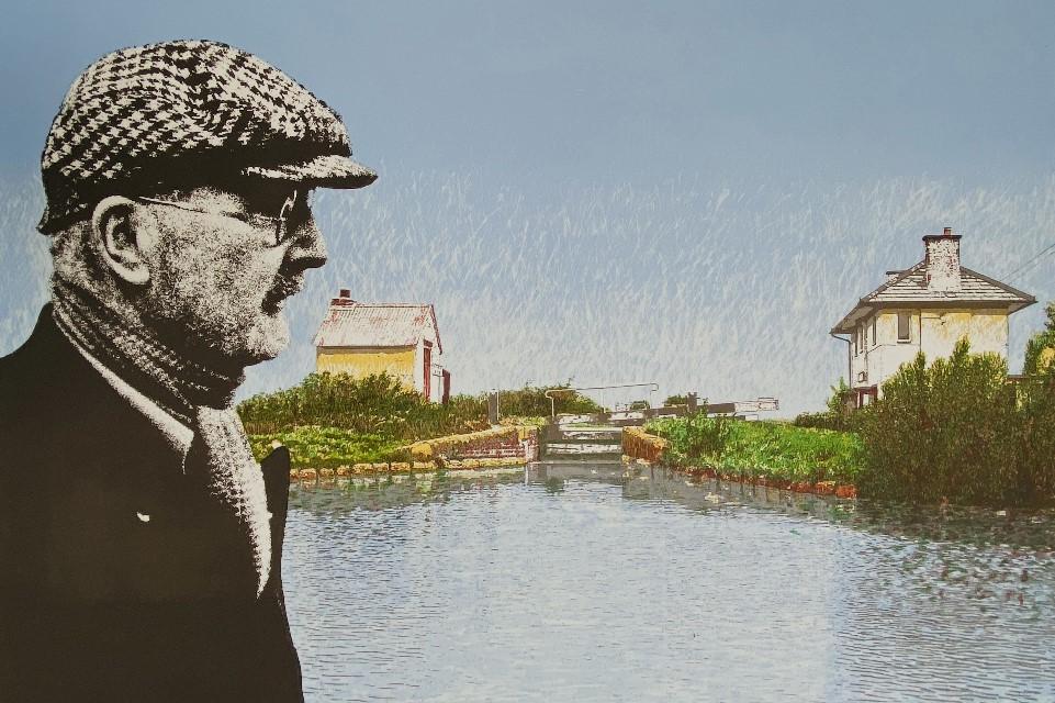 Artist print depicting a canal scene in the background with a blue sky, green bank and grey canal water. In the foreground to the left a man in a checked flat cap looks to to the right accross the canal.