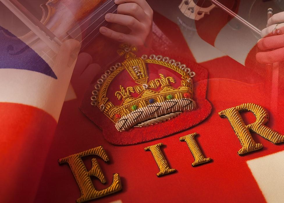 Centre of british flag featuring red section with Elizabeth II written in gold.