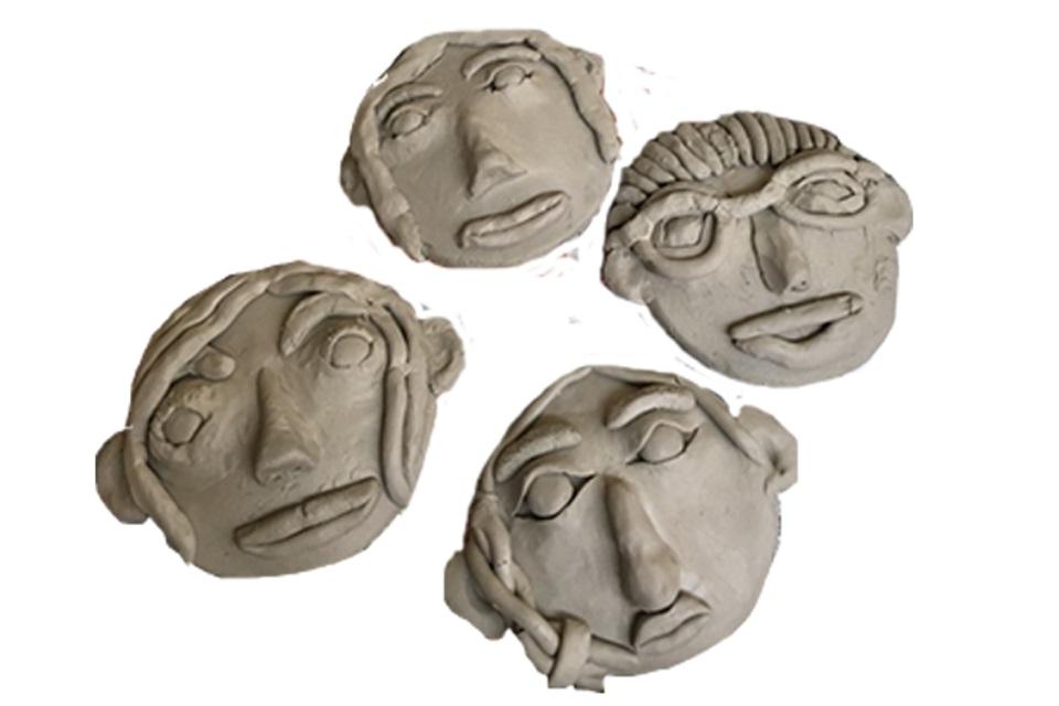 Four flat spherical clay faces one with glasses all with textured hair and distinct eyes and bushy eyebrows