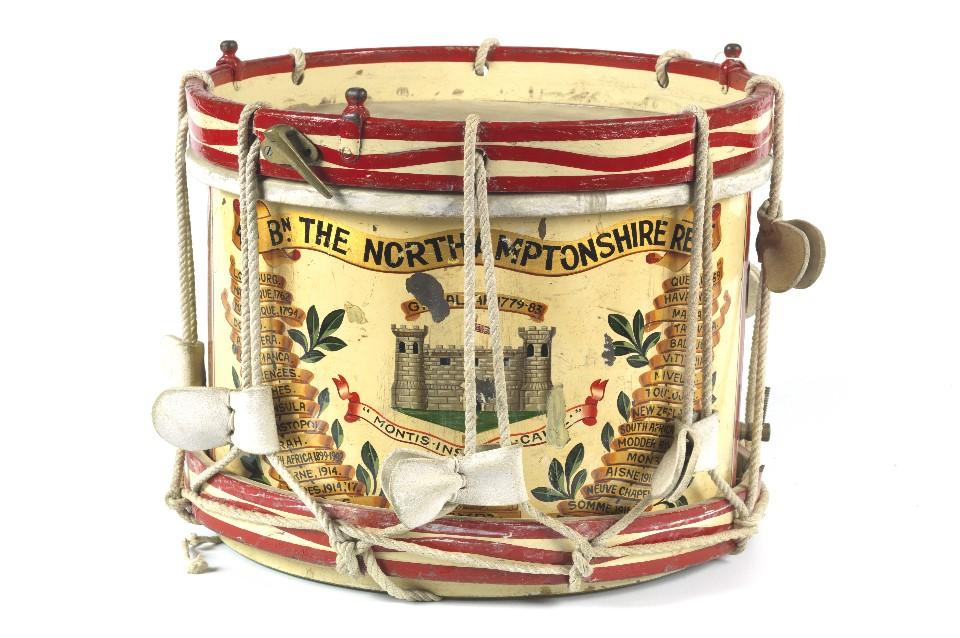 Round cylinder drum facing front on with colourful image of Northamptonshire Regiment and the words Talivera