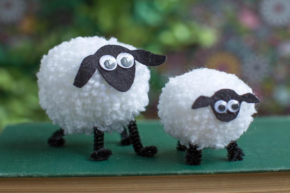 Two fluffy white pom pom sheep with black legs