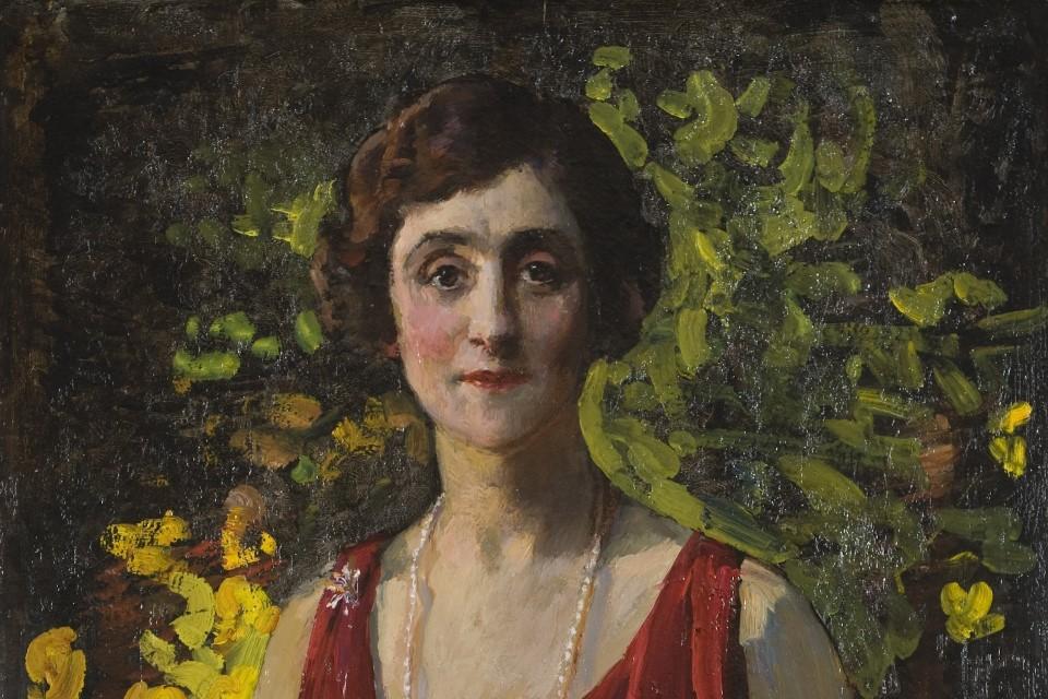 Woman in a red dress with short dark brown hair looking directly at the camera