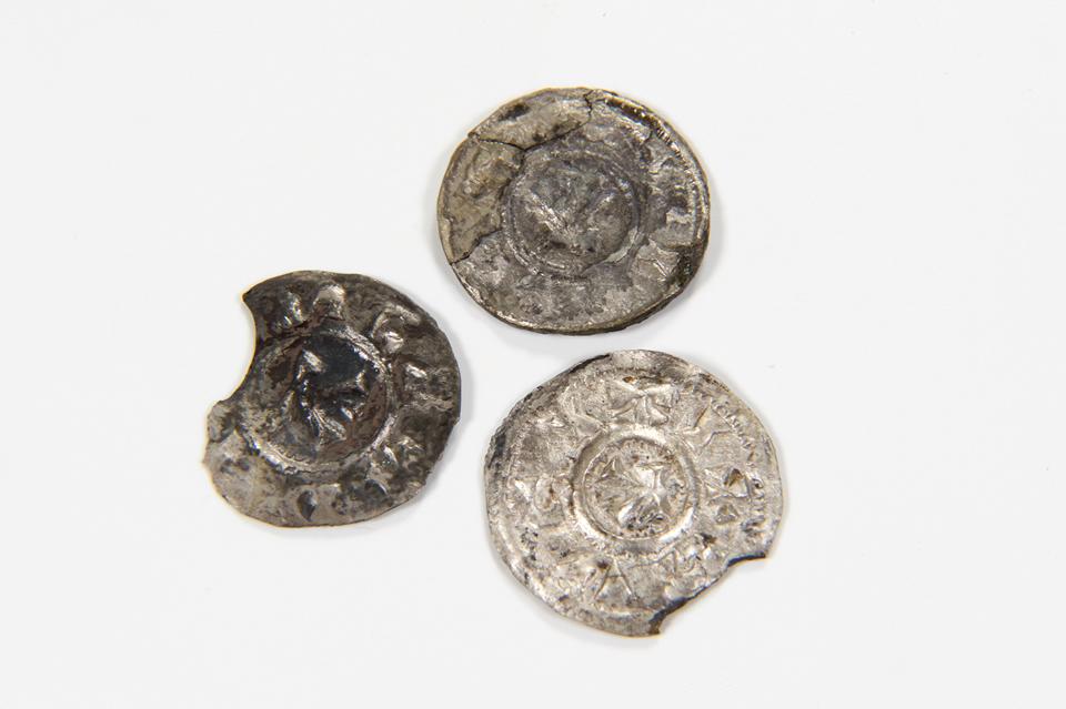 Three coins, one complete and others with areas of the circumference missing.