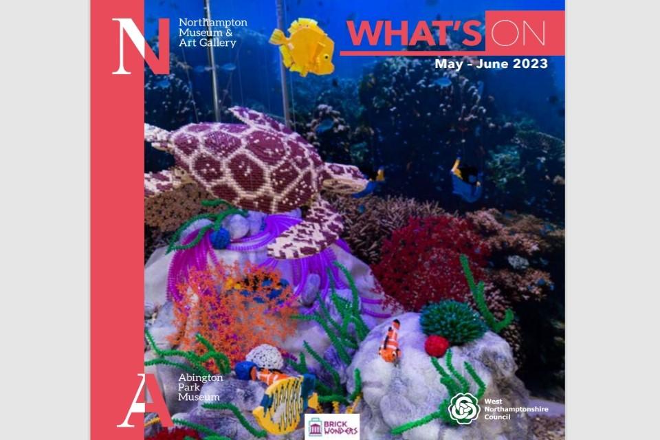 Front cover of our whats on guide with a red stripe down the left and a colourful image of a fish and underwater scene made out of lego.