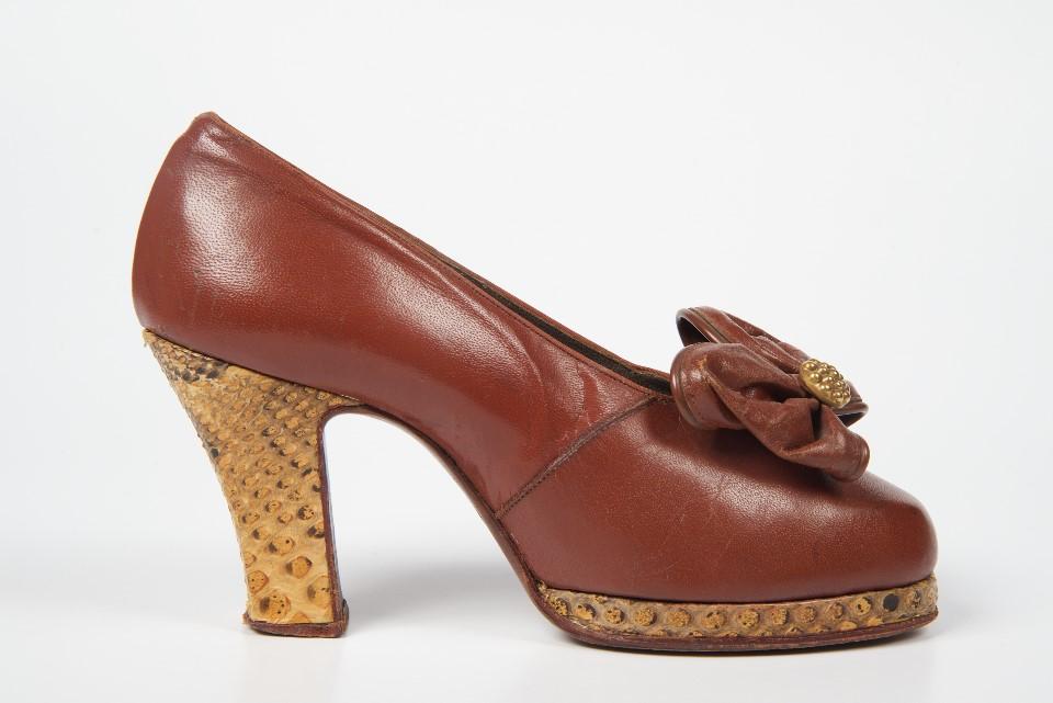 Women’s single brown leather and snakeskin court shoe.
Women, brown, leather, snakeskin, platform, covered heel, Utility, 1942, Talk, talks, shoes, footwear, 1940s, children’s, baby, school, wartime, designs, materials, 1960s