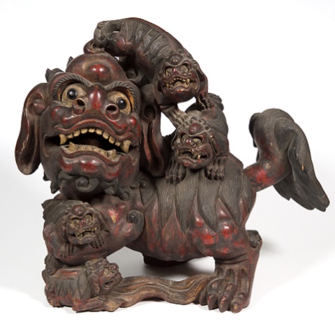 a wooden guardian lion figurine known as a foo dog