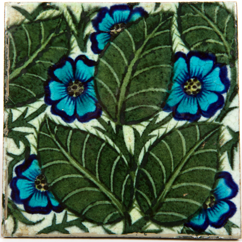 Earthenware Tile decoratived with a blue primrose design with green leaves designed by William De Morgan