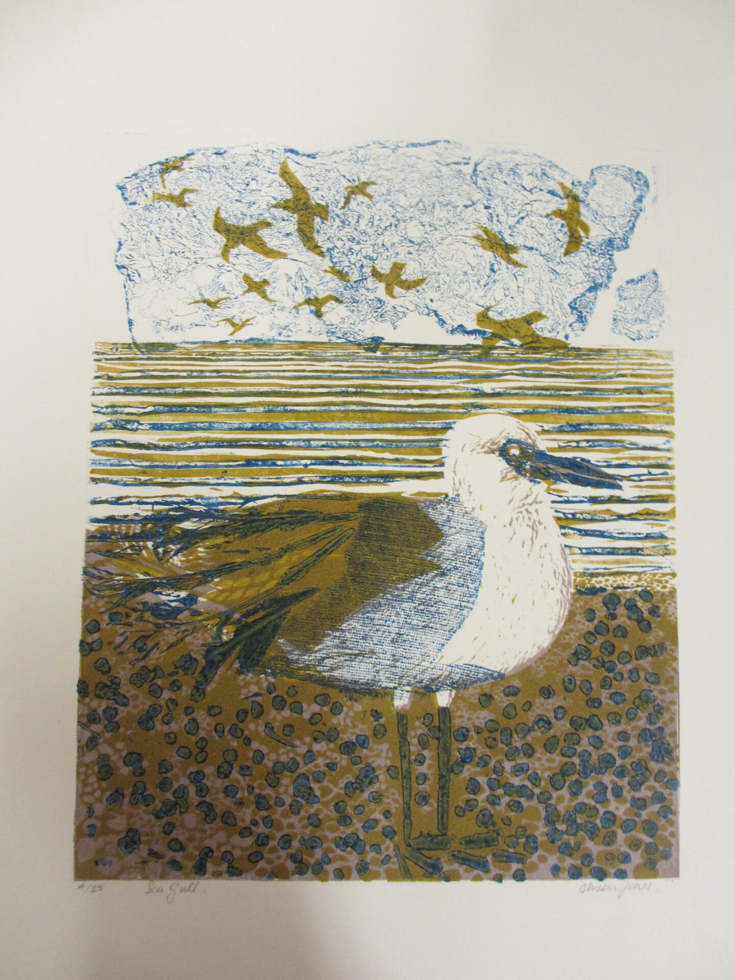 Illustrated print of a seagull standing on a pebbled shore in the foreground, with a striped blue‑and‑ochre sea behind and stylised birds flying across a pale sky.