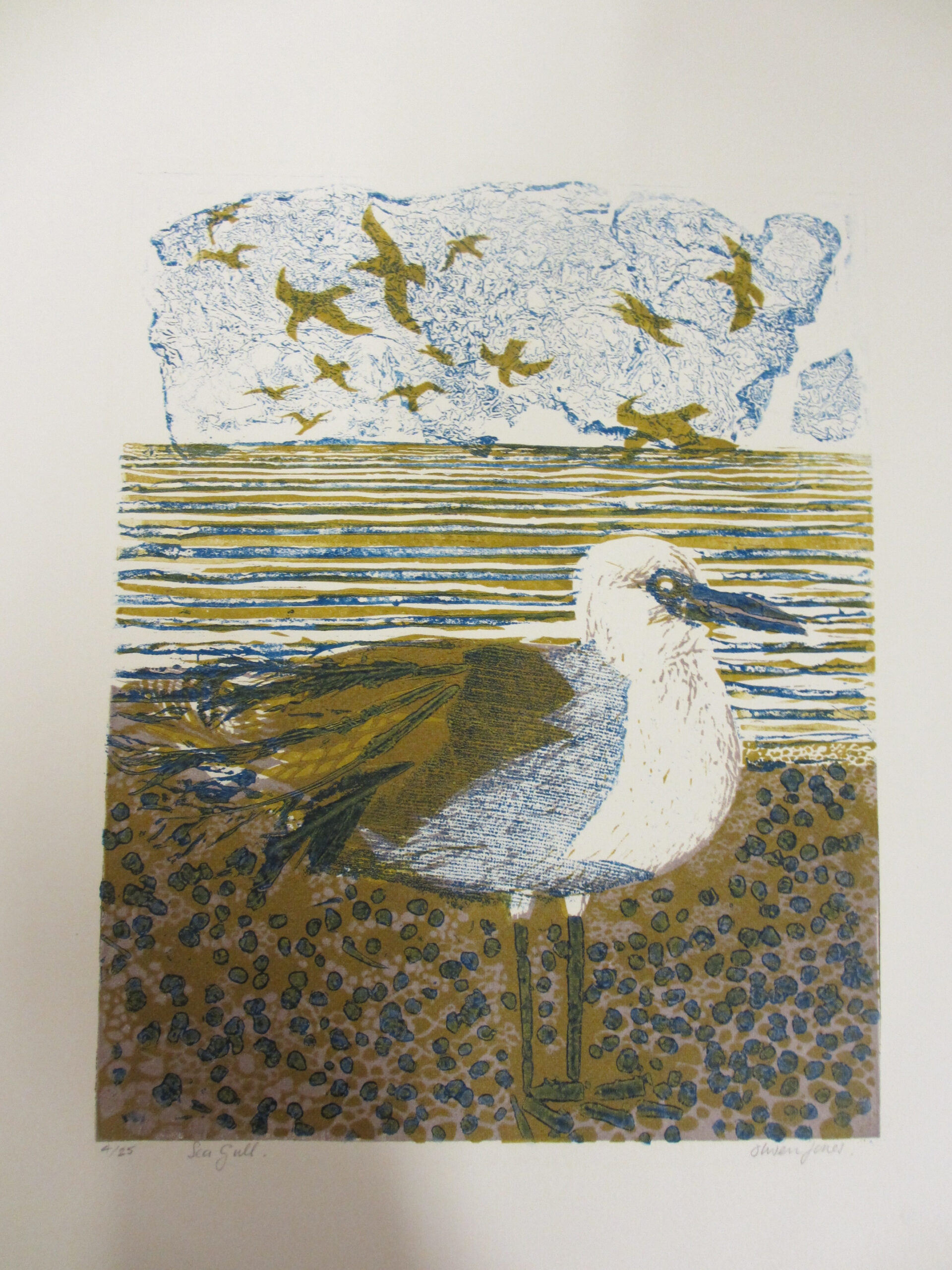 Illustrated print of a seagull standing on a pebbled shore in the foreground, with a striped blue‑and‑ochre sea behind and stylised birds flying across a pale sky.