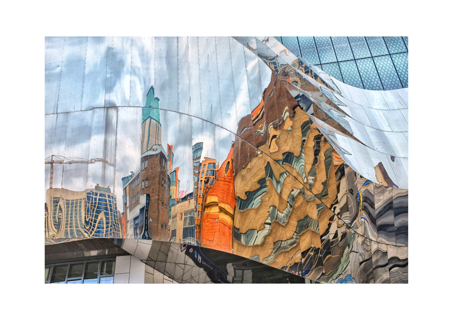 Reflection of Birmingham city buildings in the curved mirrored metal facade of a modern building, creating a colourful, distorted urban scene.