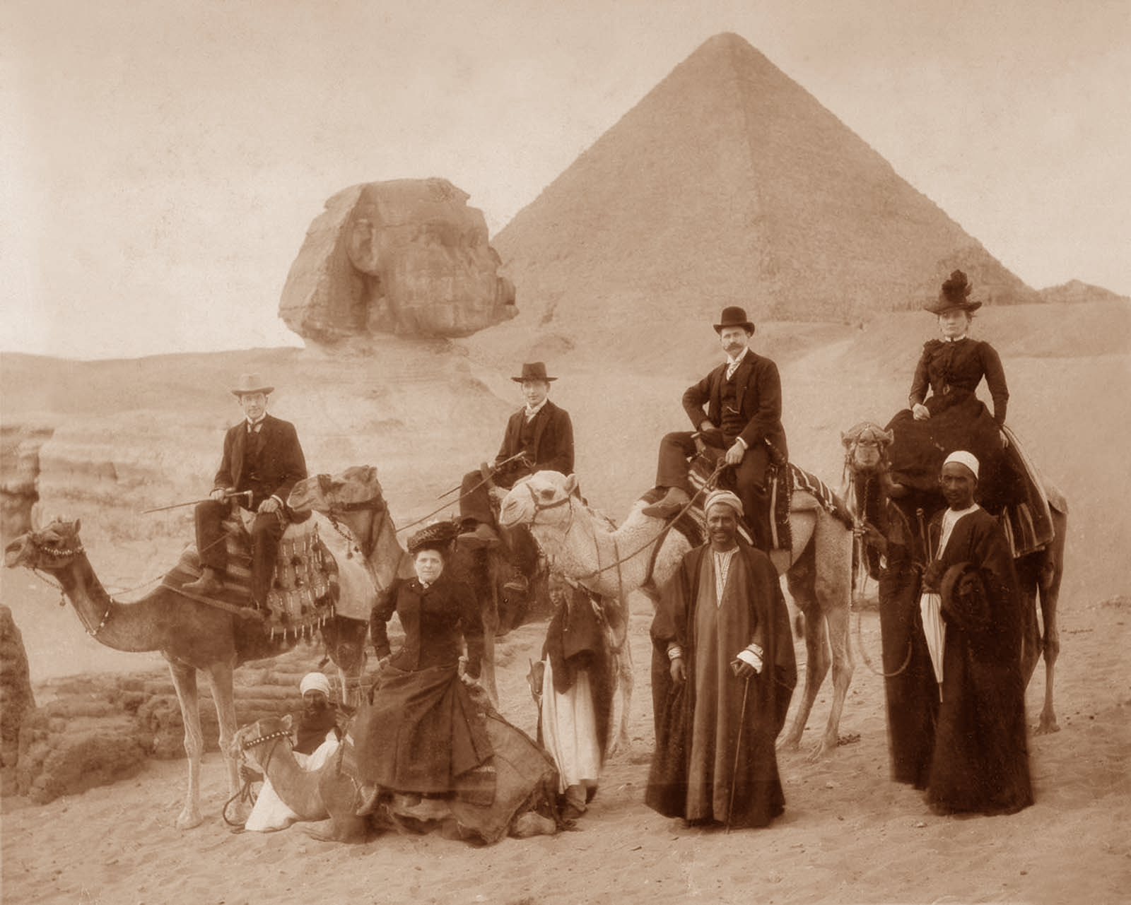 ancient pyramids Vintage photograph of travellers and guides with camels beside the Sphinx and pyramids.